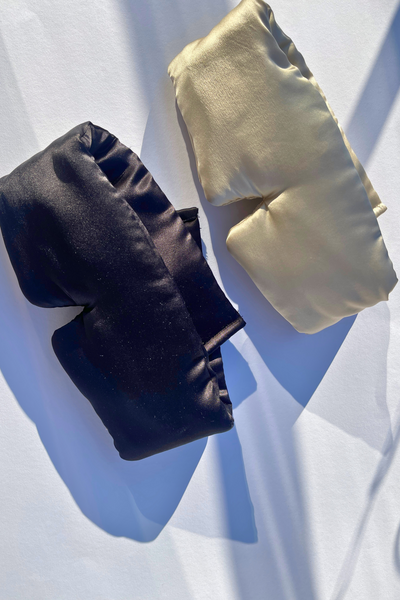 “Eyelash-protecting silk sleep mask in black, made with 22 Momme mulberry silk, shown on a neutral background.”“Zīda miega maska skropstu aizsardzībai, izgatavota no 22 Momme mulberry zīda, melnā krāsā, novietota uz neitrāla fona.”