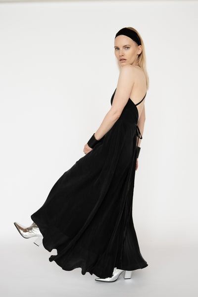 "Atvērts muguras dizains melnā Cupro zīda kleitā, kas piešķir elegantumu un vieglumu kustībām. Open back design on the black Cupro silk dress, adding elegance and fluidity to your movements."